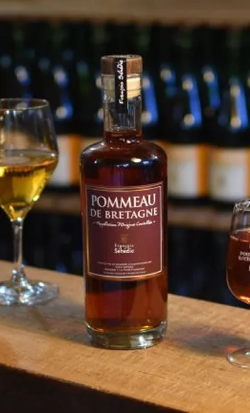 Bouteille de Pommeau de Bretagne sur un comptoir, avec deux verres remplis à Toulouse en Haute-Garonne 31