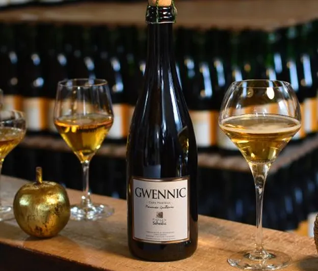 Bouteille de cidre GWENNIC et deux verres pleins sur un comptoir en bois à Toulouse en Haute-Garonne 31